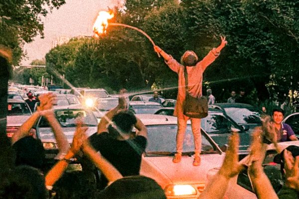 iraanse vrouw staat bij een protest op een auto